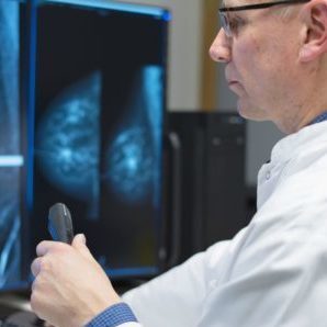 Radiologi tutkii näytöllä olevia mammografiakuvia